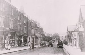 Early car parked on London Road, opposite a motor garage