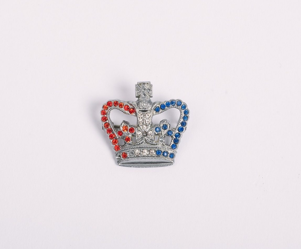 Metal crown shape with inset red, white and blue stones