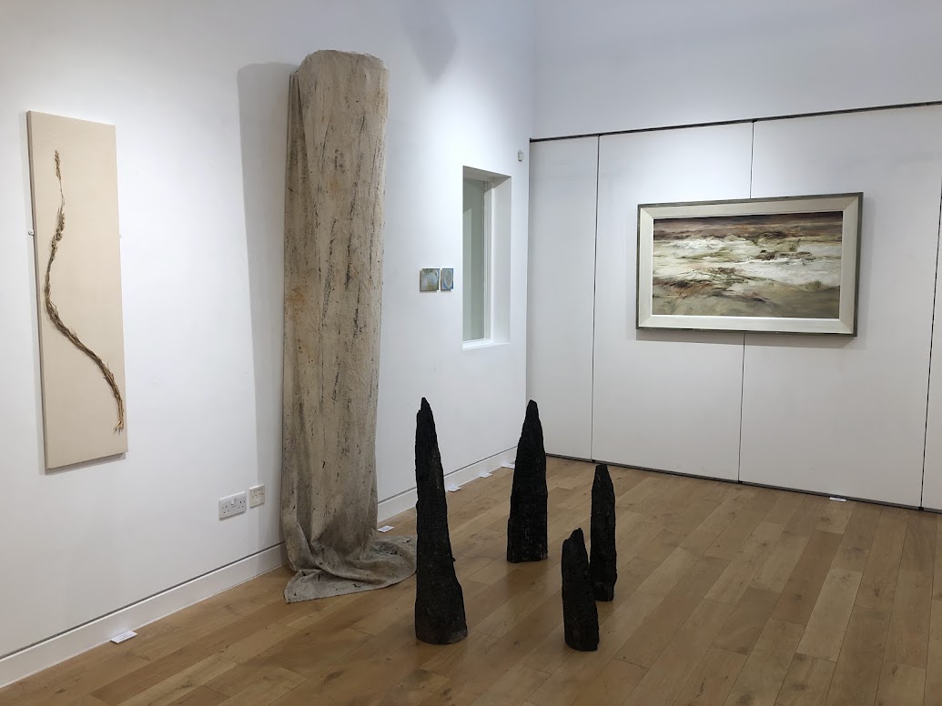 Abstract sculptures and paintings in a white room